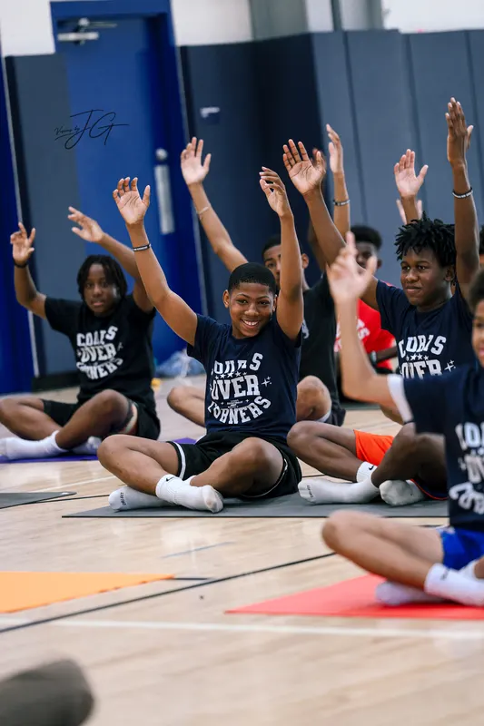 Players stretching with their arms raised during a wellness session